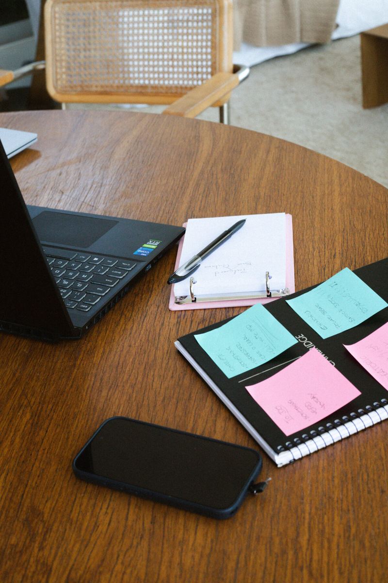 Laptop, notebook, and planning notes on a work table